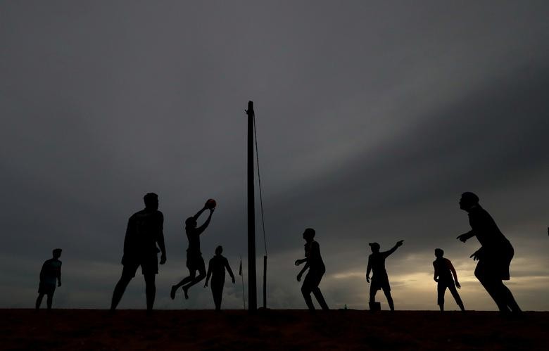 Sri Lankan youth play volleyball in the evening as rain clouds gather above them, in Colombo, Sri Lanka. REUTERS/Dinuka Liyanawatte